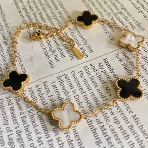 Gold clover link bracelet with black and white charms